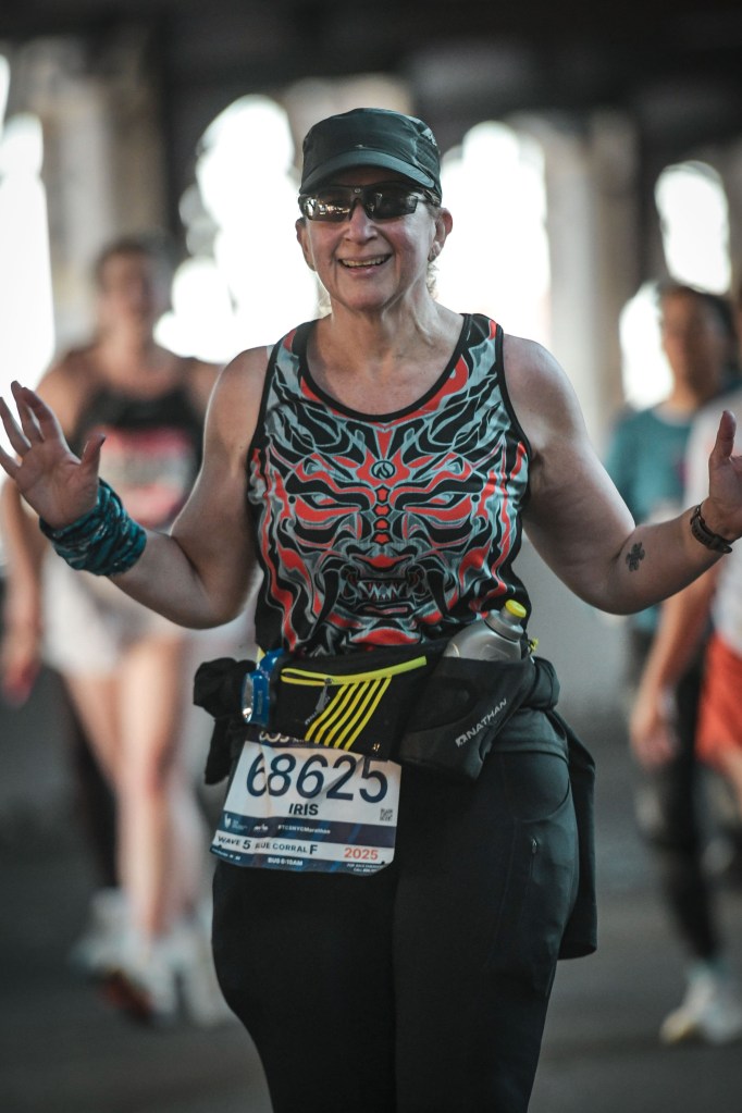 Iris running the NYC Marathon 2025, grinning, wearing the demon shirt